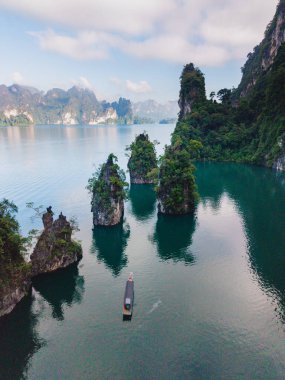 Kireçtaşı tepeleri ve yemyeşil yeşilliklerle çevrili Cheow Lan Gölü 'nün çarpıcı manzaralarını keşfedin. Khao Sok, Tayland