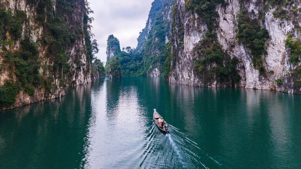 Yüksek kireçtaşı kayalıkları ve yemyeşil bitkilerle çevrili Cheow Lan Gölü 'nün sakin sularını deneyin. Geleneksel bir tekne zümrüt yüzeyi boyunca süzülüyor, Khao Sok Tayland