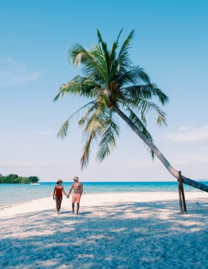 Çift, temiz mavi sular ve sallanan palmiye ağaçlarıyla çevrili Koh Kood Adası 'nın yumuşak kumlu sahilinde romantik bir yürüyüş yapmayı seviyor. Tayland 'da parlak bir gökyüzü altında mükemmel bir tropikal kaçış