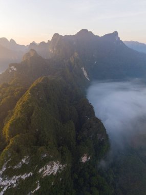Tayland 'daki Khao Sok' un nefes kesici güzelliğini tecrübe edin. Güneş yemyeşil dağların üzerinden yükselirken..