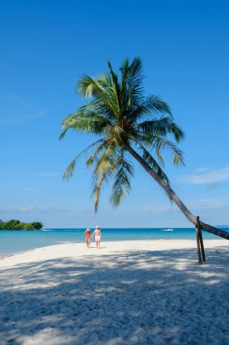 İki gezgin, sallanan palmiye ağaçları ve Tayland 'ın el değmemiş turkuaz sularıyla çevrili Koh Kood Adası' nın kumlu sahillerinde geziniyor.