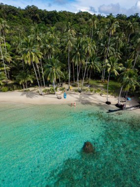Doğal güzellik Koh Kood Adası 'nda baş döndürücü turkuaz suları, beyaz kumlu plajları ve sallanan palmiye ağaçları ile gözler önüne seriliyor. Ziyaretçiler rahatlama ve keşfe girişiyor, bu huzurlu kaçışın tadını çıkarıyorlar..