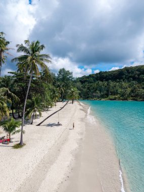 Koh Kood Adası 'nın el değmemiş kumlu sahillerinde gevşeyin. Palmiye ağaçları hafif esintide sallanırken. Berrak turkuaz su, ziyaretçileri bulutların altında huzurlu bir tropikal kaçamağın tadını çıkarmaya davet ediyor..