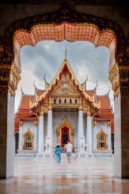 Ziyaretçiler, Bangkok 'taki Mermer Tapınak olarak da bilinen Wat Benchamabophit' in karmaşık tasarımına hayran kaldılar. Canlı renkler ve çarpıcı detaylar yansıma için sakin bir atmosfer yaratır..