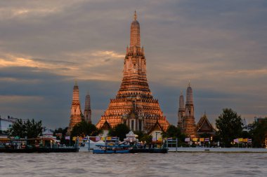 Wat Arun alacakaranlık gökyüzüne karşı zarifçe duruyor, ayrıntıları vurgulanıyor. Chao Phraya Nehri alacakaranlıktaki renkleri yansıtır ve Bangkok 'ta sakin bir atmosfer yaratır..