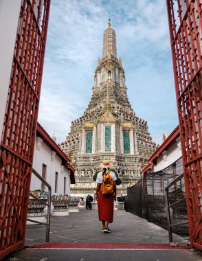 Bir gezgin, Bangkok, Tayland 'da Şafak Tapınağı olarak da bilinen Wat Arun' un süslü girişine doğru yürür..