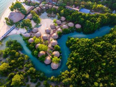 Tayland 'daki Koh Phayam Adası' nın sakin güzelliğini keşfedin. Canlı doğanın kır evleriyle buluştuğu yer. Yumuşak güneş ışığı, bereketli manzaranın ve huzurlu suların üzerine altın bir renk salıyor..