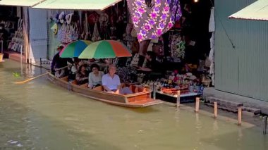 Ratchaburi, Thailand, 7 December 2025, Lively atmosphere of Damnoen Saduak Floating Market, where colorful boats glide through the water, showcasing local crafts and delicious street food