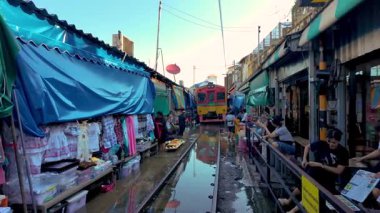Maeklong Railway Market, Thailand, 7 December 2025, flooded train track, where colorful stalls line the train tracks. As vendors showcase their goods, the train passes by