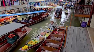 Ratchaburi, Tayland, 7 Aralık 2025 Damnoen Saduak yüzen pazarının kanallarında renkli ahşap botlar var. Satıcılar taze meyve, yerel lezzetler ve el yapımı mallar satıyor..