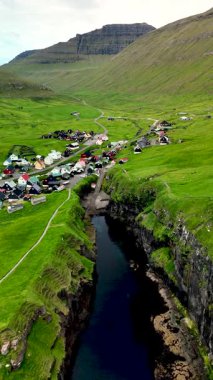Faroe Adaları 'ndaki Gjogv köyünün huzurunu yaşayın. Etrafı dramatik manzaralar ve yuvarlanan tepelerle çevrili..