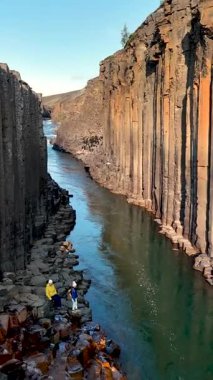 İzlanda 'daki Studlagil Kanyonu' nun muhteşem güzelliğini keşfedin. Yüksek bazalt sütunlar ve sakin bir nehir. Bu eşsiz konum keşif ve fotoğrafçılık için mükemmel fırsatlar sunar..