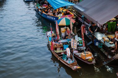 Amphawa Yüzen Pazarı, Tayland 5 Aralık 2025. Ziyaretçiler, bu ünlü pazarın hareketli atmosferini yaşarken taze ürünler ve yerel atıştırmalıklarla dolu renkli teknelerden alışveriş yapmayı seviyorlar..