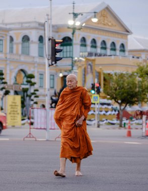Bangkok, Tayland, 19 Kasım 2025. Geleneksel cübbeli dingin bir keşiş, görkemli Wat Phra Kaew 'ın yakınlarında düşünceli bir şekilde gezinerek, kültürün ve maneviyatın eşsiz bir harmanını yakalıyor..