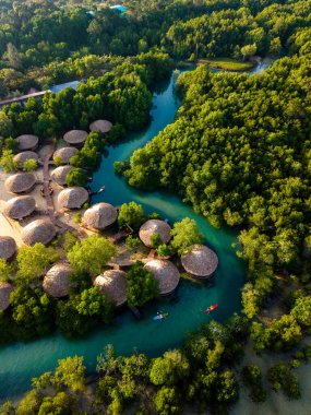 Göz kamaştırıcı Koh Phayam Adası manzarası canlı yeşil mangrovlar ve sakin suların arasına yerleşmiş geleneksel kır evlerini gösteriyor. Rahatlama ve macera arayanlar için mükemmel..
