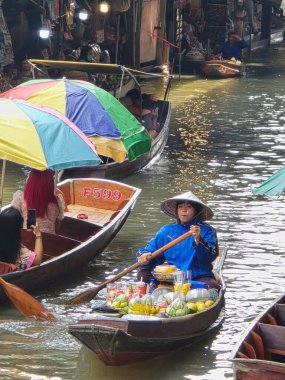 Damnoen Saduak Yüzen Pazarı, Tayland, 5 Aralık 2025. Satıcıların turistlere meyve sattığı güneşli bir günde Tayland 'daki canlı Damnoen Saduak Yüzen Pazarı' nı keşfedin.