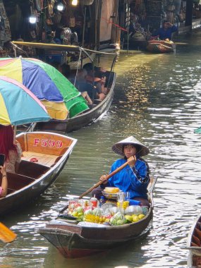 Damnoen Saduak Yüzen Pazarı, Tayland, 5 Aralık 2025. Tedarikçiler temiz sularda kürek çekip taze ürünler, lezzetli sokak yemekleri ve renkli hatıralar satarak canlı bir sahne yaratıyorlar..