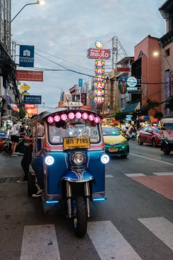 Bangkok, Tayland, 19 Kasım 2025, Çin Mahallesi 'nin hareketli sokakları renkli neon ışıklarda yol alırken canlanıyor. Meşgul satıcılar ve hareketli kalabalık enerjik bir atmosfer yaratıyor..