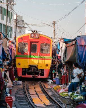 Maeklong Demiryolu Pazarı 'nın hareketli atmosferini seyir halinde seyir halindeki bir tren gibi düşünün. Canlı sahneyi renkli ürünler ve yerel ürünler dolduruyor, Tayland kültürünü gözler önüne seriyor.