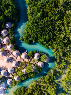 Tayland 'daki Koh Phayam Adası' nın sakin suları çevreleyen büyüleyici bungalovlarını deneyin. Oteli ve mangrov ağacı olan bir nehir.