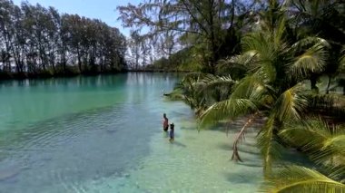 Tayland, Koh Kood 'un dingin cazibesini keşfedin. İki arkadaş, bereketli palmiye ağaçlarıyla çevrili sularda yüzüyorlar. Her karede tropikal cennetin gerçek özünü tecrübe et..