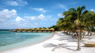 Aruba 27 Mart 2021 'de ziyaretçiler, yumuşak beyaz kumların kristal berrak suyla buluştuğu bakir Aruba sahillerinde güneşli bir günün tadını çıkarıyorlar..