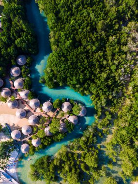 Koh Phayam Adası Tayland 'da yemyeşil mangrovlar ve eşsiz sahil kulübeleriyle çevrili canlı turkuaz sular sergileniyor. Bu tropikal cennet, sakin bir atmosferde rahatlama ve keşfe davet ediyor..