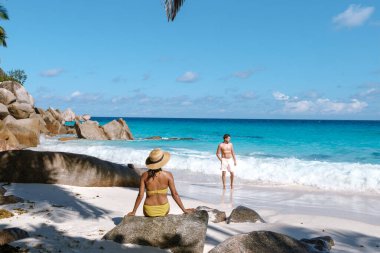 Bir çift, bereketli palmiye ağaçları ve çarpıcı turkuaz sularla çevrili Anse Georgette 'in el değmemiş kumlarında romantik bir günün tadını çıkarıyor. Praslin Seyşeller