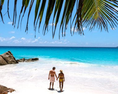 Bir çift Anse Georgette 'in çarpıcı kıyı şeridi boyunca el ele yürür, turkuaz dalgalar beyaz kumu nazikçe öper. Seyşeller 'in tropikal cennetinde mükemmel bir kaçış..