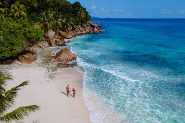 Bir çift, yemyeşil ve turkuaz sularla çevrili Anse Patates 'in el değmemiş kumlarında romantik bir yürüyüş yapıyor. Seyşeller 'deki bu huzurlu plaj tatilciler için mükemmel bir kaçış yolu sunuyor..