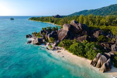 Granit kayaların yumuşak beyaz kum ve kristal berrak sularla buluştuğu Anse Source d 'Argent plajının güzelliğinin tadını çıkarın. La Digue, Seyşeller 'deki bu tropik cenneti keşfedin..