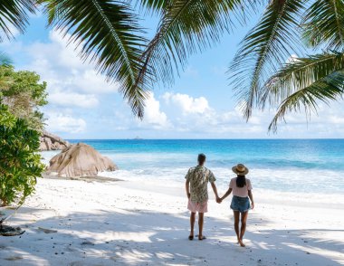 Romantik bir çift, bereketli palmiyeler ve turkuaz sularla çevrili Anse Patates 'in yumuşak beyaz kumları boyunca yürür. Sakin atmosfer onu mükemmel bir tropikal kaçış yapar. La Digue, Seyşeller