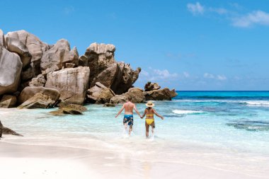 Anse Cocos plajı boyunca el ele yürürken, yumuşak dalgalar kıyıda tur atıyor. Büyüleyici manzarada büyük granit kayalar ve kristal berrak sular, La Digue Seyşeller yer almaktadır.