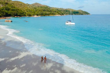 Parlak turkuaz sular el değmemiş sahilde yavaşça dolaşırken bir çift Anse Lazio sahilinde, Praslin 'de, Seyşeller' de el ele yürüyor..