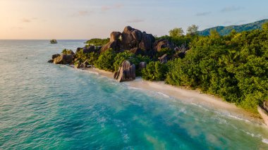 Anse Source d 'Argent' ın nefes kesici güzelliğini tecrübe edin. Altın güneş ışığı huzurlu plajı yıkarken. Kristal berrak sular granit kayalara, La Digue 'ye, Seyşeller' e çarpar