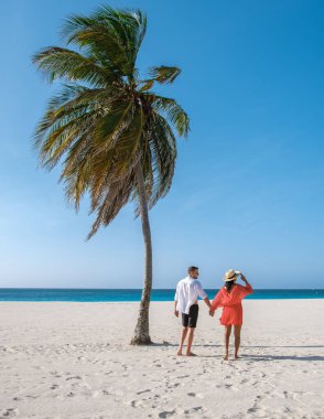 Kartal Sahili 'nde güzel bir günde bir çift, yumuşak, beyaz kum üzerinde el ele yürür. Turkuaz dalgalar yavaşça kıyıya vurarak Aruba 'daki bu romantik kaçış için sakin bir zemin oluşturur..