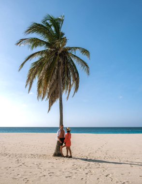 Yumuşak kumlar ve turkuaz sular Aruba 'daki Eagle Beach' te kucaklaşan bir çift için mükemmel bir zemin oluşturur..