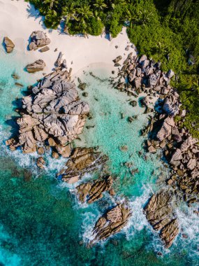 Kristal berraklığında turkuaz sular Anse Cocos plajında eşsiz kaya oluşumlarını kucaklıyor, Seyşeller 'in La Digue kentinde sakin bir cennet. Tropikal bir ortamda tatil ve rahatlama için ideal..