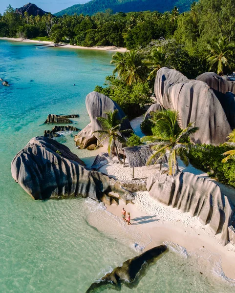 Bir çift, Anse Source d 'Argent plajında büyüleyici granit kayaların kristal berrak sularla buluştuğu büyüleyici cenneti keşfeder. Palmiye ağaçları ılık meltemde sallanıyor, La Digue, Seyşeller