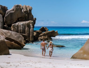 Bir çift, Anse Cocos plajı boyunca el ele romantik bir gezinti yapar, kristal berrak sular ve eşsiz kaya oluşumları Seyşeller 'de güzel bir sahne yaratır..
