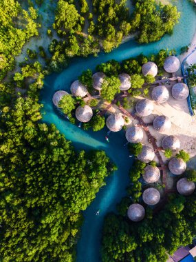 Koh Phayam Adası 'nın göz kamaştırıcı manzarasını keşfedin, canlı mangrovlarla çevrili sakin su yollarını ve bereketli günışığında yemyeşil gölgeliklerin altına yerleştirilmiş büyüleyici sahil kulübelerini keşfedin..