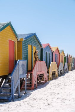 Renkli plaj kulübeleri Cape Town 'daki Muizenberg plajı boyunca çarpıcı bir zemin oluşturur. Turistler güneşten ve hareketli atmosferden zevk alarak, burayı tatil ve rahatlama için ideal bir yer haline getiriyor..