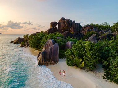 Güneş batarken Anse Source d 'Argent kıyılarında birkaç tur atıp görkemli granit kayalara ve gür bitki örtüsüne altın bir parıltı saçarak romantik bir atmosfer yarattılar. La Digue, Seyşeller