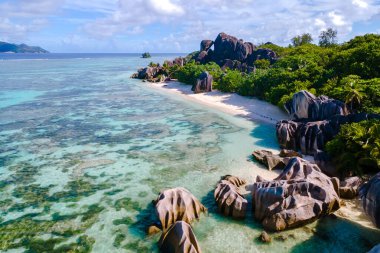 Soft sands and majestic granite rocks define Anse Source d'Argent beach on La Digue, Seychelles. This tropical paradise invites travelers to relax, explore, and soak in stunning ocean views.
