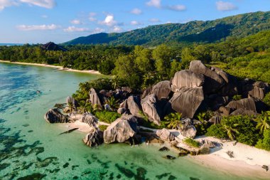 Kristal berrak sular, verimli yeşillik ve eşsiz granit oluşumlarıyla çevrili Anse Kaynak d 'Argent sahillerinde yavaşça tur atar. La Digue, Seyşeller 'de mükemmel bir tropikal kaçış.