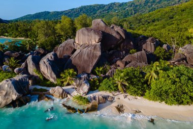 Kristal berraklığında turkuaz sular, Seyşeller 'in sakin La Digue adasında bulunan Anse Source d' Argent plajının baş döndürücü granit kayaları ve beyaz kumlu sahillerine nazikçe çarpar..