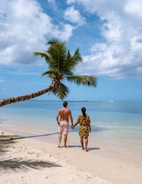 Seyşeller 'deki Anse Royale sahillerinde romantik bir çift, ılık güneşin ve hafif okyanus esintisinin tadını çıkarıyor..