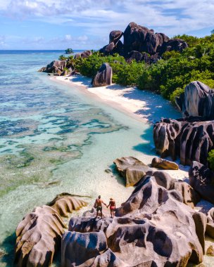 Turkuaz sular Anse Source d 'Argent' taki yumuşak beyaz kumları öper. Arkadaşlar yemyeşil yemyeşil ortamda eşsiz kaya oluşumlarını keşfeder. La Digue, Seyşeller cennetinde unutulmaz anılar yaratır..