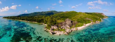 Turkuaz suların beyaz kumla buluştuğu Anse Kaynak d 'Argent plajının çarpıcı manzarasını keşfedin. La Digue Seyşeller