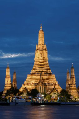 Şafak Tapınağı Wat Arun, alacakaranlıkta Chao Phraya nehri boyunca görkemli bir şekilde duruyor, akşam gökyüzüne karşı güzelce aydınlatılmış. Bangkok Tayland 'da mükemmel bir seyahat yeri..